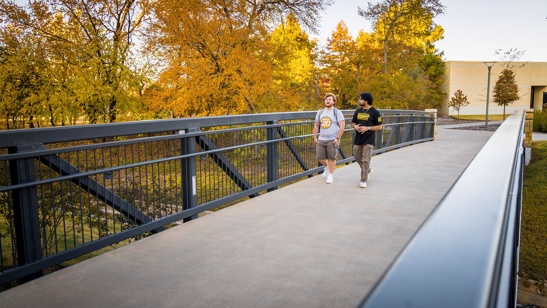 two students walking on a bridge