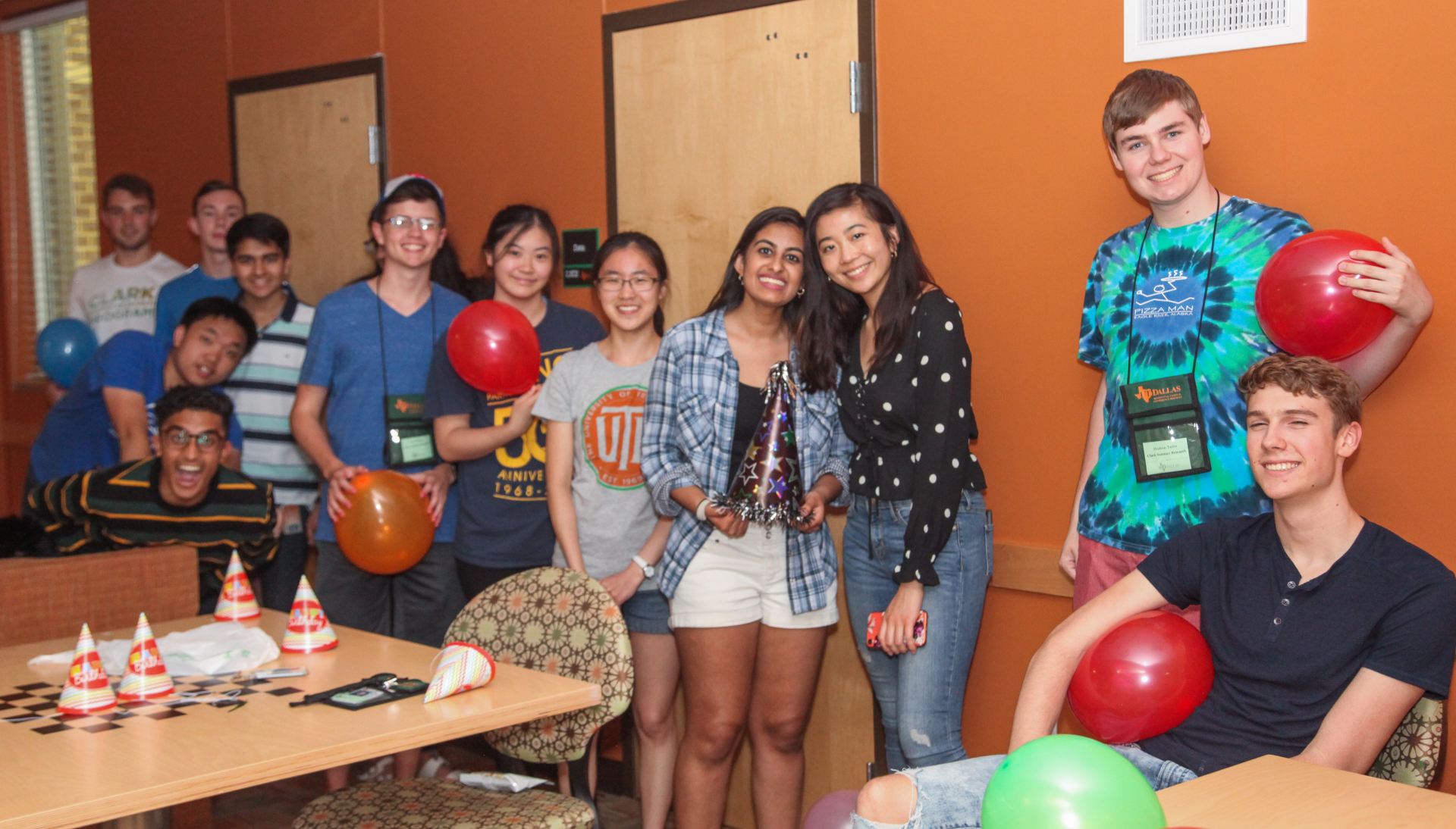 Students holding balloons at a birthday party.